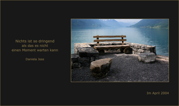 Eine Holzbank mit wunderbarem Ausblick am Seeufer.
