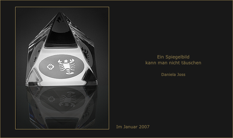 Glasprisma mit eingraviertem Krebs, wirft eine Spiegelung auf den Tisch.