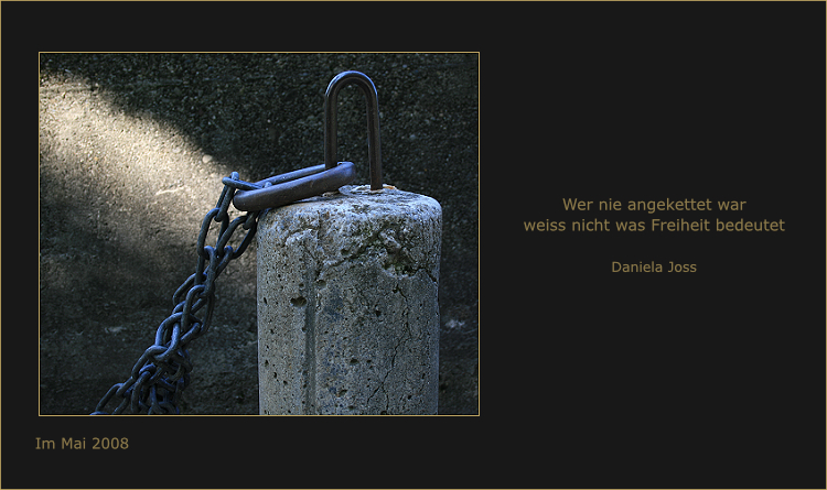 Eine schwere Kette hängt an einem Betonpfosten.