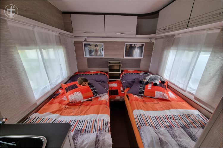 Eingerichtetes Schlafzimmer mit zwei Längsbetten im Wohnwagen